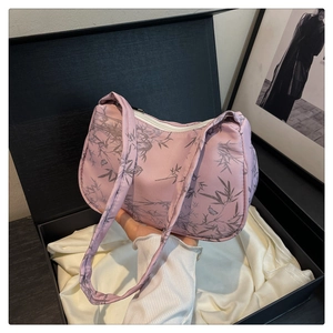 Detail of pink shoulder bag with bamboo leaf print held over white satin lining