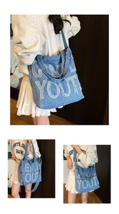 Macro shot of blue denim tote bag featuring fringe GEN YOUR letter embroidery and texture