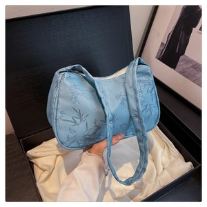Close-up of light blue silk tote bag with bamboo patterns in a premium gift box set
