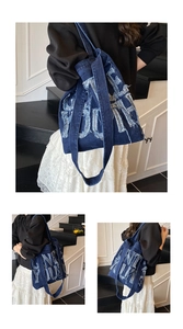 Close-up of dark blue denim tote bag featuring distressed 3D letter embroidery and textures