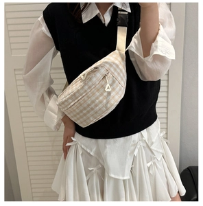 Detail of plaid canvas crossbody bag with delicate flower pattern and mesh strap