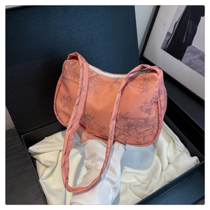 Detail of pink shoulder bag with bamboo print displayed in a luxury gift box