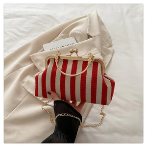 Detail of red and white striped straw bag with gold metallic frame and sphere clasp