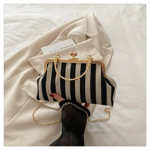 Close-up of vintage black and white striped clutch with ornate gold handle and frame