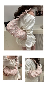 Detail of floral shoulder bag with ruched strap and bow in light pink and green colors