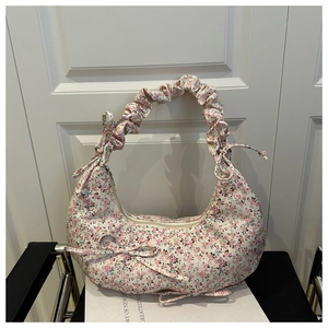 Detail of floral hobo bag with pleated handle and decorative pink ribbon bows