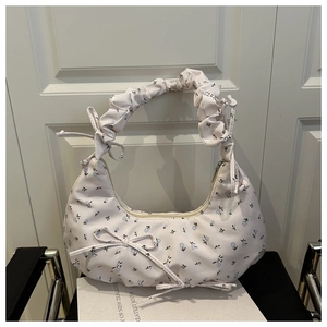 Close-up of pink floral crescent handbag with ruffled handle and bow detail