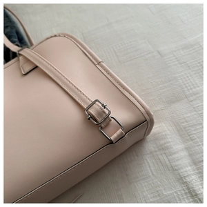 Detail der hellbeige Kunstledertasche mit silberner Metallschnalle und sauberer Naht