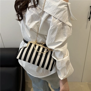 Fashionable black and white vertical striped straw handbag with gold chain and metal frame
