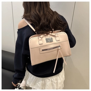 Detail eines hellrosa Kunstleder-Rucksacks mit Silberplatte und Reißverschlusstasche