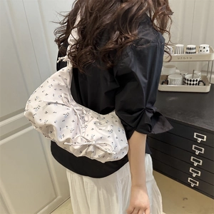 Floral print shoulder bag with side drawstring details and delicate bow accents