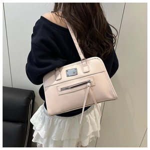 Detailansicht der rosa Lederschultertasche mit Silberplakette und Quasten-Reißverschluss