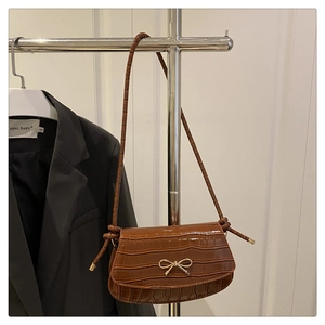 Brown crocodile pattern shoulder bag with a gold bow buckle on a silver hanger