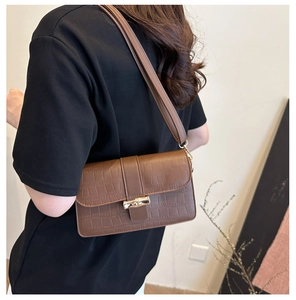 Detailed view of crocodile texture leather shoulder bag with vintage bamboo clasp