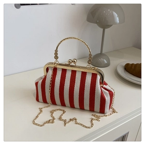 Détail d'un sac docteur en toile rayée rouge et blanc avec fermoir rétro et chaîne dorée