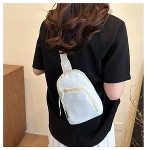 Détail du sac bandoulière crème minimaliste montrant la texture nylon et la poche à fermeture
