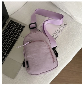 Détail du sac bandoulière en nylon violet clair avec sangle réglable et étiquette tissée