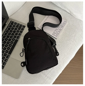 Détail du sac de poitrine en nylon noir avec fermeture éclair et bandoulière