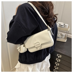 Detail view of cream white lychee pattern crossbody bag with mini charm pouch