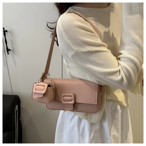 Detailed close-up of a pink litchi texture faux leather baguette bag with a mini pouch
