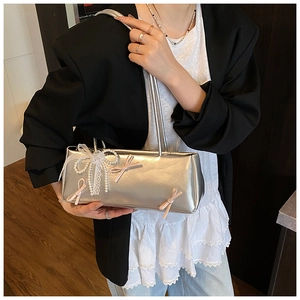 Detail of silver metallic shoulder bag with pink bows and lace pearl pendant decoration