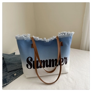 Detail of blue and white gradient canvas tote with frayed edges and Summer print