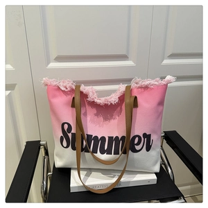 Detail of pink gradient canvas tote bag with tassel fringe and Summer print on chair