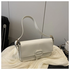 Close-up of white minimalist crossbody bag with lychee grain texture on silk fabric