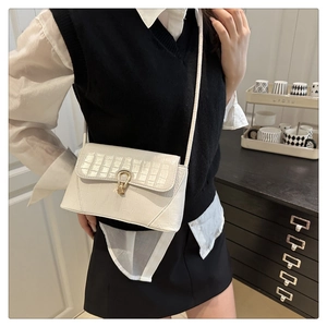 Detailed close-up of white crocodile pattern shoulder bag with a gold horseshoe buckle