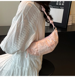 Pink crescent hobo bag with delicate butterfly embroidery and knotted strap details