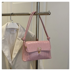 Pink faux crocodile leather handbag featuring a stylish gold horseshoe buckle detail