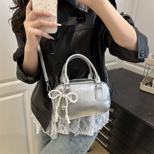 Silver metallic pillow bag with pearl bow and heart charm for stylish summer commuting