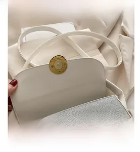 Detailed view of the saddle bag with white leather lining and golden magnetic closure