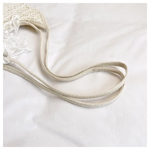 Close-up of white lace fabric texture and durable canvas shoulder strap stitching