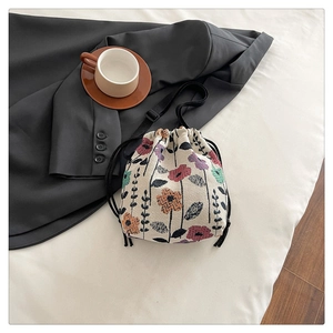 Detail of floral jacquard bucket bag with adjustable black strap and drawstring closure