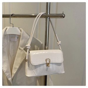 Close-up of white croc-effect leather handbag with a gold water-drop shaped metal lock