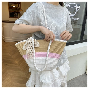 Detail of tricolor woven straw tote bag with lace ribbon and thick white rope handles