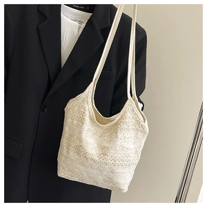 Close-up of white floral lace tote bag with intricate hollow texture and shoulder straps