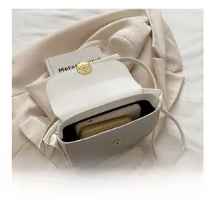 Practical interior capacity of the minimalist flap bag showing phone and wallet storage