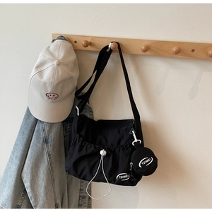 Detail der schwarzen Nylon-Umhängetasche mit Kordelzugtasche und rundem TZIMEI-Logo-Beutel