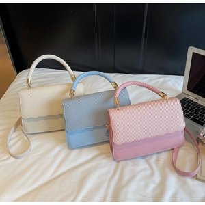 Close-up of woven texture and wavy edge detail on stylish multi-color handbags