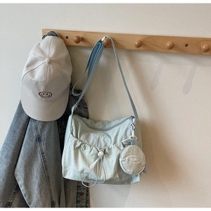 Detail der mintgrünen Nylon-Umhängetasche mit Kordelzugfach und rundem Münzfach