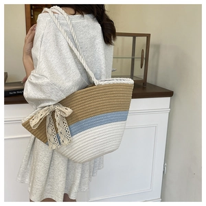 Detail of tricolor woven bucket bag with beige lace bow and white cotton rope strap