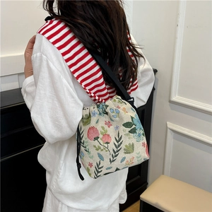 Floral knit bucket bag with drawstring closure and colorful vintage botanical pattern