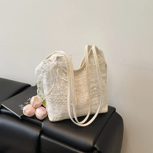 Chic beige lace tote bag with crochet texture and ribbon bow on a stylish seat