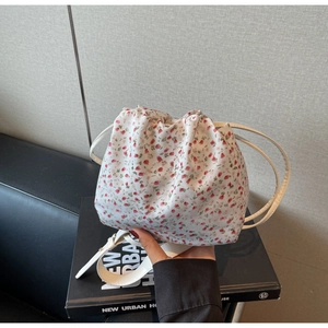 Detail of floral canvas bucket bag showing soft pleated texture and pink flower pattern