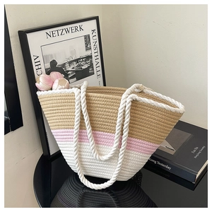 Detail of tricolor woven tote bag showing thick white rope handles and textured knit patterns