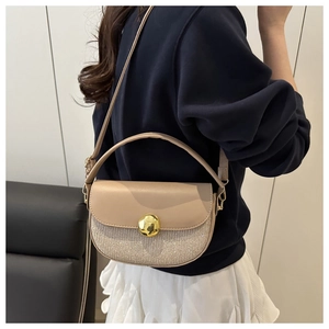 Chic beige half-moon bag with glitter texture and gold buckle shown on a fashion model