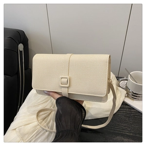 Detail of a creamy beige woven texture crossbody bag with matching square buckle and strap