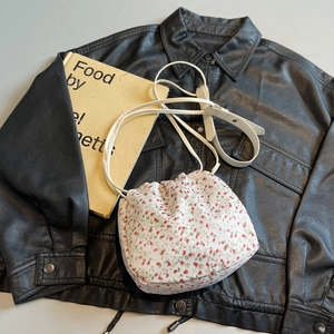 Floral canvas drawstring bucket bag with pink flower pattern and leather shoulder strap